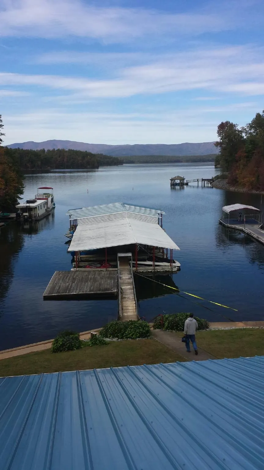 View across a lake from a newly installed blue metal roof in Millmont
