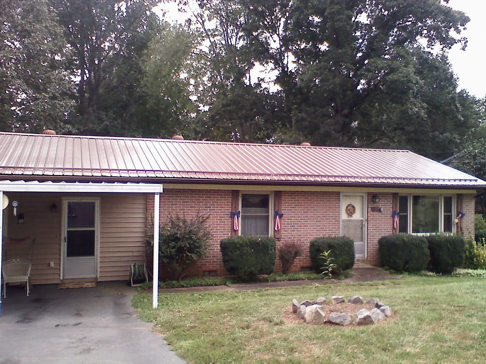 Bronze metal roof and carport on a brick ranch home — Roof Repair work by our crew in Millmont